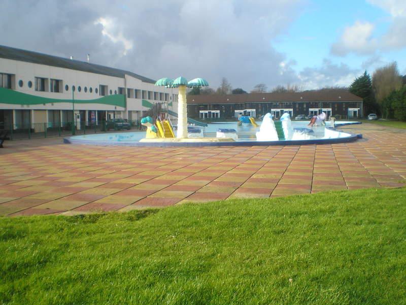 The outdoor funpool with the old reception building to the left and deluxe chalets in the background