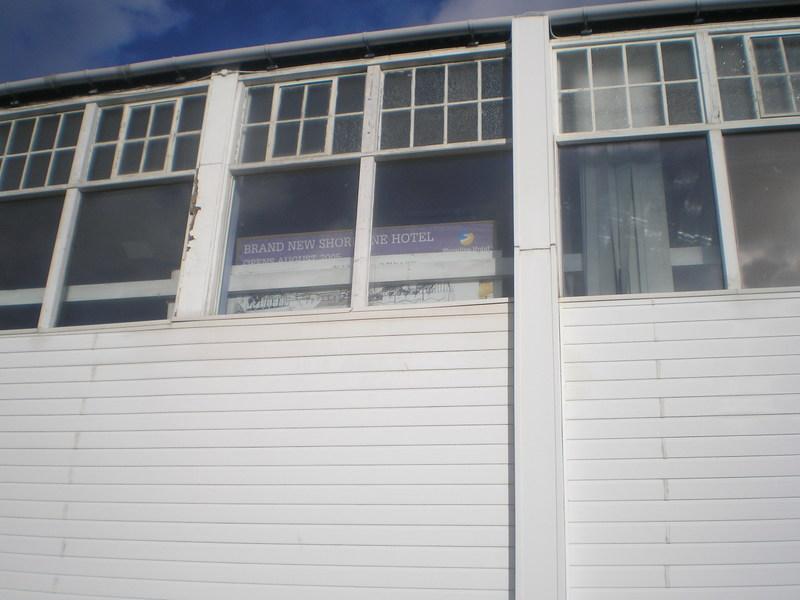 Advertisement for the Shoreline Hotel in an upstairs window at the back of the old reception building