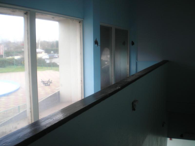 View from the top of some stairs inside the old reception building with the funpool visible through the window