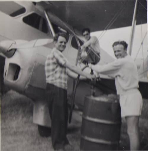 Gus Britten filling up the aeroplane, assisted by Ron, with the pilot in the background